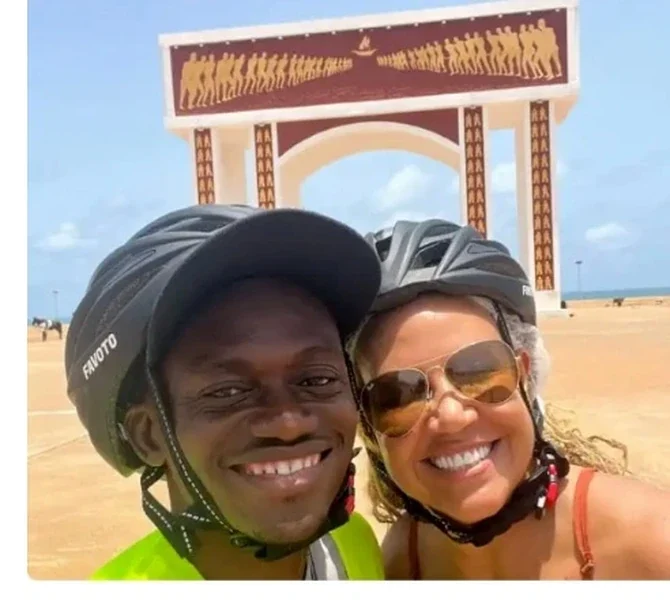 Lisa and a guide in bike helmets under a stone arch