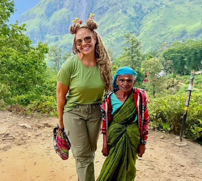 Lisa with a local woman on a hillside path in Sri Lanka