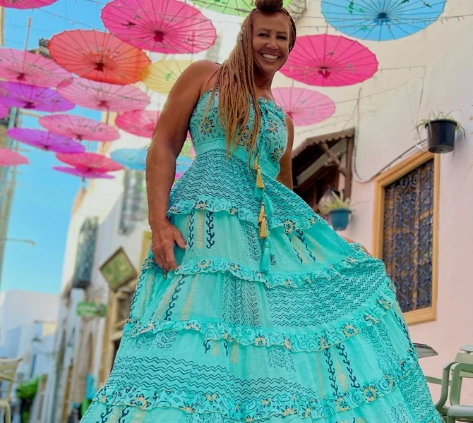 Lisa in a turquoise dress under hanging umbrellas